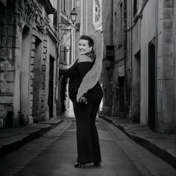 Femme en robe longue dans une ruelle, en noir et blanc