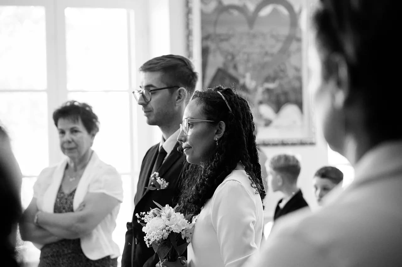 Les mariés et leurs proches pendant la cérémonie, en noir et blanc
