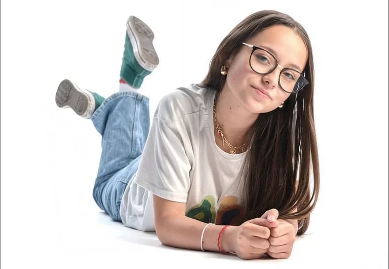 Adolescente à lunettes allongée sur le ventre, souriante