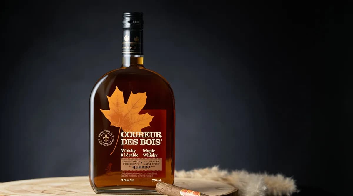 Bouteille de whisky à l’érable Coureur des Bois sur un plateau de bois